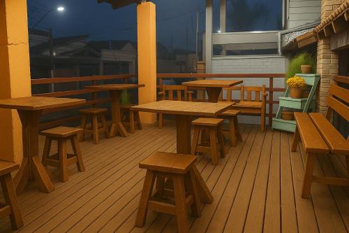 eine Gruppe von Tischen und Bänken auf einem Deck in der Unterkunft Pousada Primavera in Cachoeira Paulista