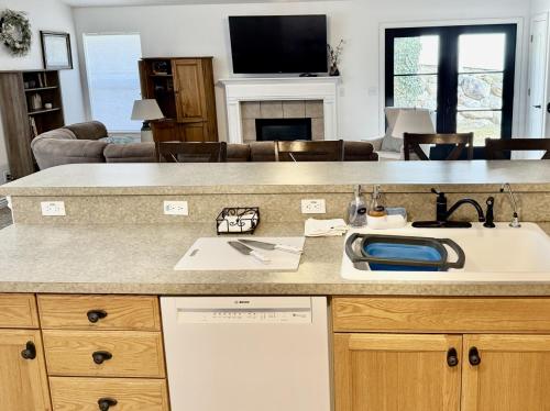 a kitchen with a sink and a living room at Charming Provo Home close to BYU and Utah Lake in Provo