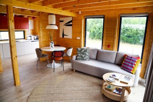 una sala de estar con un sofá y una mesa en Domki Na Lato, en Łukęcin
