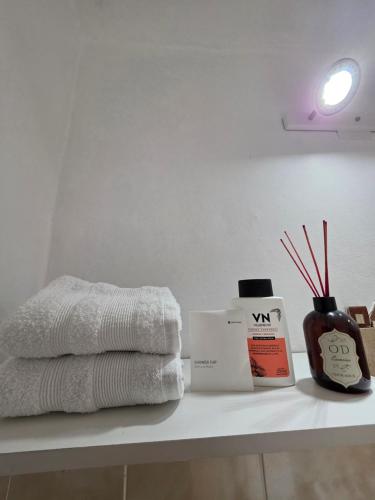 a bathroom counter with towels and a bottle of soap at El Nidito Casa in Chilecito
