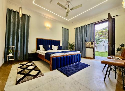 a bedroom with a blue bed and a large window at G-town living in Gurgaon