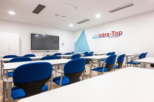 a conference room with tables and chairs and a screen at GF Fañabe in Adeje