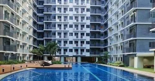 a large apartment building with a large swimming pool at Mao condotel shore 3 residence in Manila