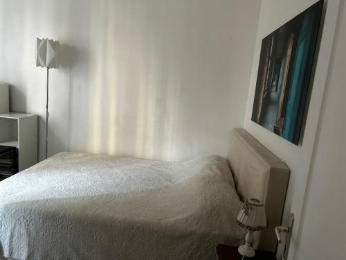 ein Schlafzimmer mit einem Bett und einem Bild an der Wand in der Unterkunft Studio centre ville in La Celle-sous-Gouzon