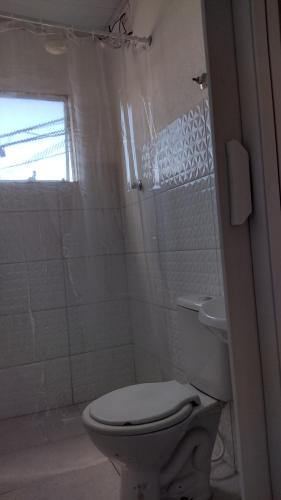 a white bathroom with a toilet and a shower at Paulo in Guarujá
