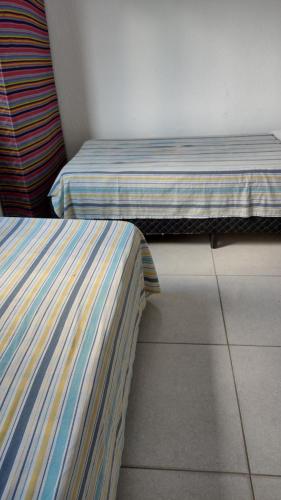 two beds sitting next to each other in a room at Paulo in Guarujá