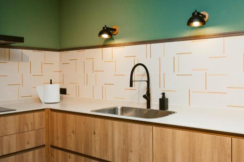 a kitchen counter with a sink and two lights at Hostal Ainhoa in Tafalla