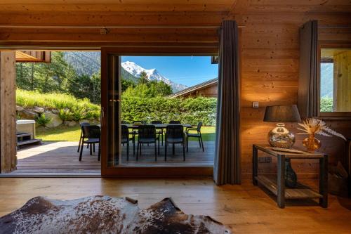 une salle à manger avec une grande porte vitrée donnant sur un patio dans l'établissement Chalet Planards 2, à Chamonix-Mont-Blanc