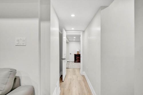 a hallway with white walls and a white couch at Cozy Caledon Getaway - Suite B in Brampton
