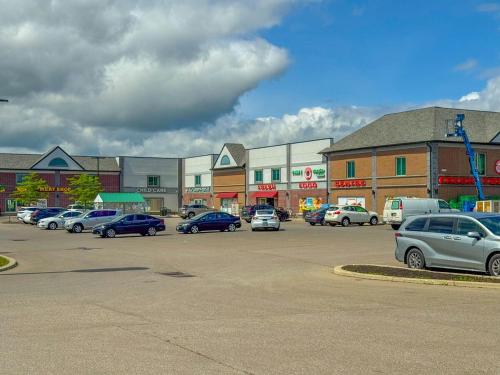 a parking lot with cars parked in front of a building at Cozy Caledon Getaway - Suite B in Brampton