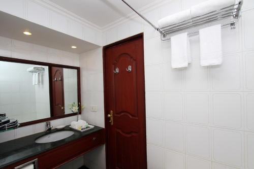 a bathroom with a sink and a wooden door at The Rialto Hotel in Bengaluru
