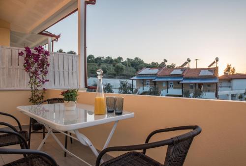 a white table and chairs on a balcony with a view at Caretta Village in Toroni