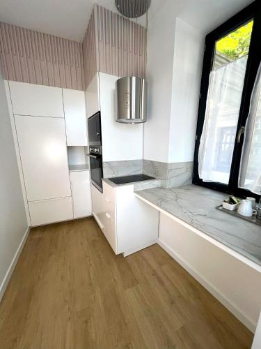 a kitchen with white cabinets and a window at Villa Noellet - Clermont Ferrand in Aubière