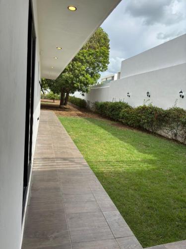 a walkway next to a green yard with a building at Hotel Boutique Casa Zafra in Campeche