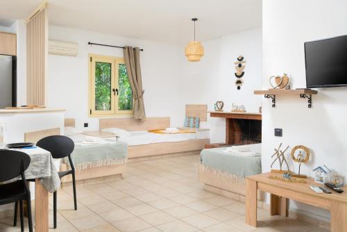 a living room with two beds and a fireplace at Renia's Villas in Hersonissos