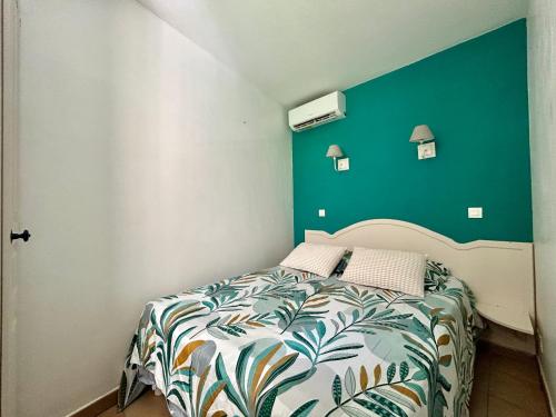 a bedroom with a bed with a green wall at Les Restanques 2149 vue mer in Grimaud