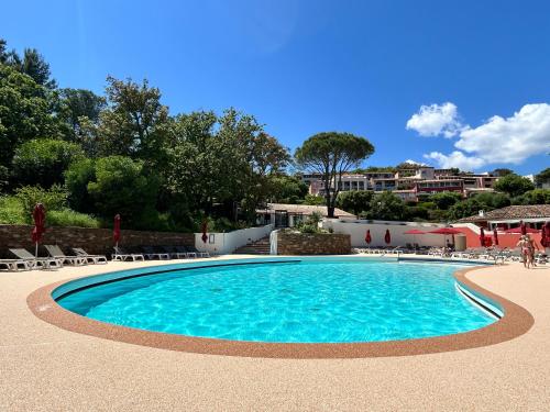 a swimming pool in a resort with chairs and trees at Les Restanques 2149 vue mer in Grimaud