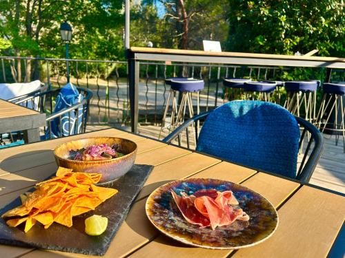 a wooden table with two plates of food on it at Les Restanques 2149 vue mer in Grimaud