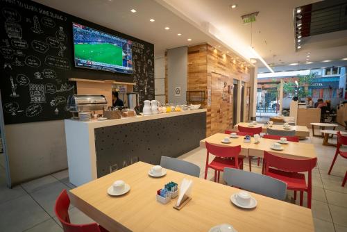 a restaurant with wooden tables and chairs and a tv at America Del Sur Hostel Buenos Aires in Buenos Aires