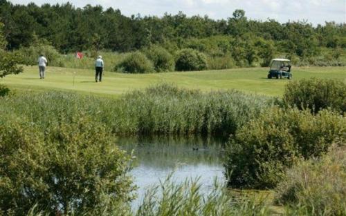a couple of people playing golf on a golf course at Boutique Hotel Texel in De Cocksdorp