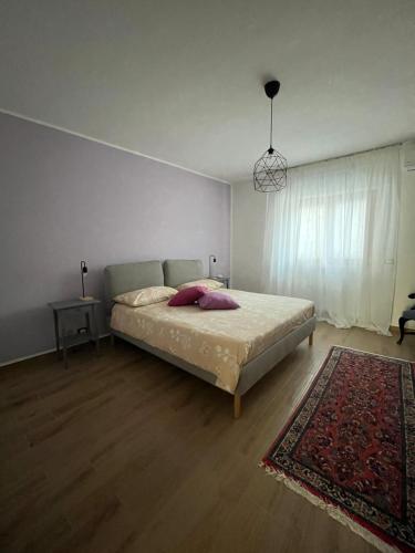 1 dormitorio con 1 cama con alfombra y ventana en B&B Ginevra, en Taranto