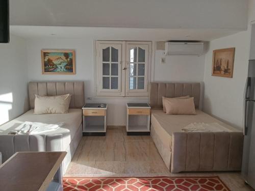 ein Wohnzimmer mit zwei Betten und einer Couch in der Unterkunft studio 1 or 2 1bed room sea view by the pool green beach v114 in El-Alamein