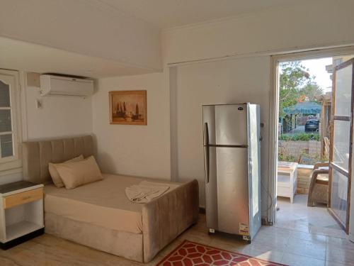 ein Schlafzimmer mit einem Bett und einem Kühlschrank. in der Unterkunft studio 1 or 2 1bed room sea view by the pool green beach v114 in El-Alamein
