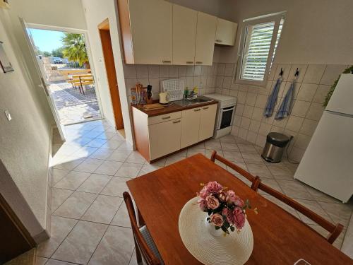 a kitchen with a table with a bowl of flowers on it at Apartments Alma in Orebić
