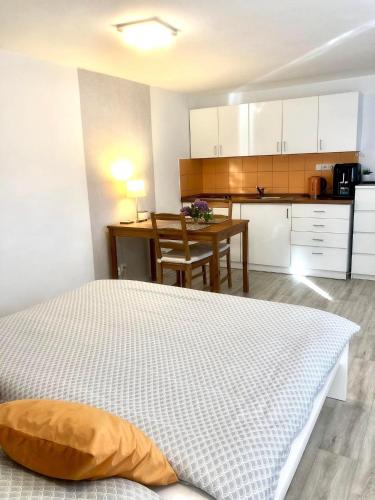 a bedroom with a bed and a kitchen with a table at Pozlovice - Apartmán Sisi in Luhačovice