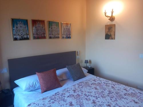 una camera da letto con un letto e alcuni quadri sul muro di Appartamento Dolce Sguardo su Orvieto a Orvieto