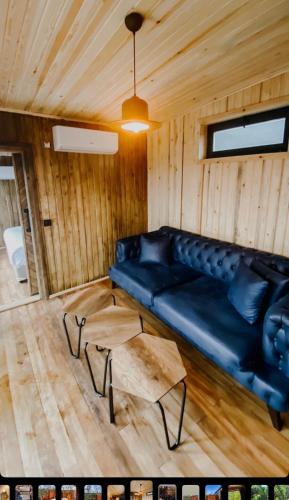 a living room with a black couch and a table at Pamera Garden Hotel in Kılıçlı