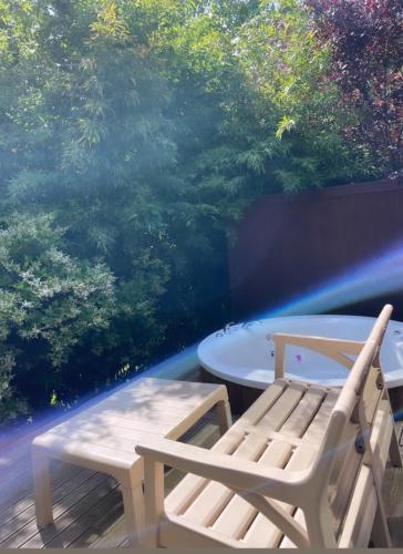 a table and a bench on a deck with trees at Pamera Garden Hotel in Kılıçlı