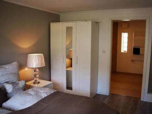 a bedroom with a bed and a lamp and a closet at Apartment am Weinberg in Deidesheim
