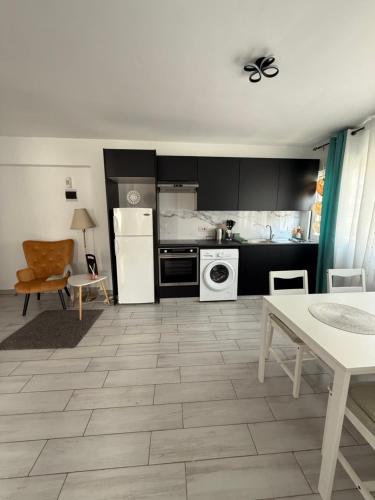 a kitchen with black cabinets and a white appliance at Kypa rooms 50 steps to the beach in Larnaka