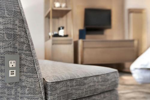 a bedroom with a bed with a couch and a tv at Madison Marriott South in Madison