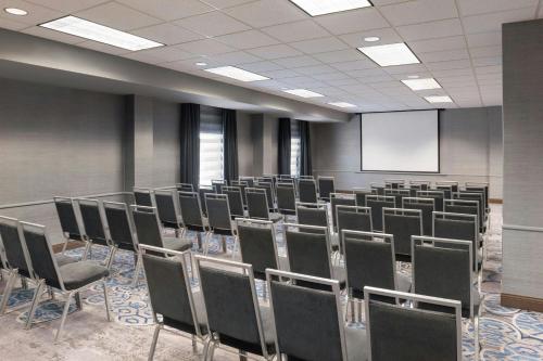 a room with rows of chairs and a screen at Madison Marriott South in Madison