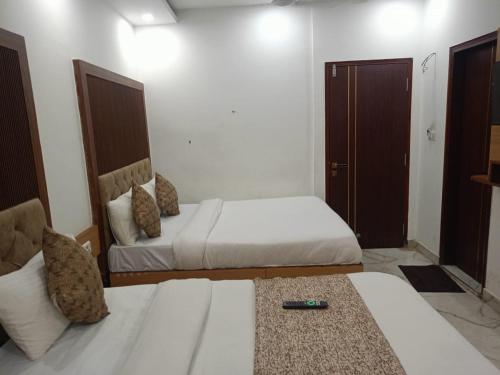 a hotel room with two beds and a couch at Hotel C G Newly Built 2 Mins From Connaught Place and Railway Station & 5 Mins From VFS Shivaji Stadium Metro Station in New Delhi