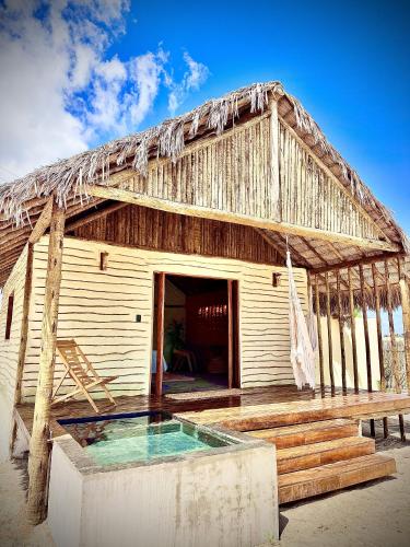 a resort with a pool and a thatched roof at São Francisco Ecopousada in Guriú
