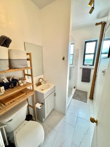 a bathroom with a toilet and a sink at Sunny Jersey City 1BR, 25 min to NYC, 15min to EWR, King Bed, Hammock & Park Views in Jersey City