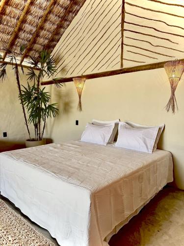 a bedroom with a bed with white sheets and pillows at São Francisco Ecopousada in Guriú