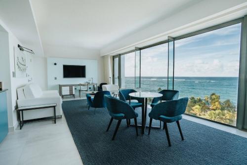 a living room with a table and chairs and the ocean at La Concha Resort, Puerto Rico, Autograph Collection in San Juan