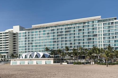 a large building with palm trees in front of it at La Concha Resort, Puerto Rico, Autograph Collection in San Juan