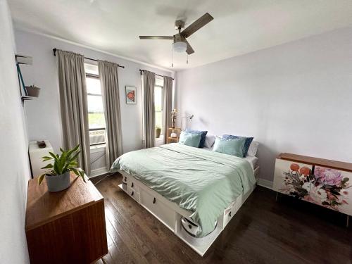 a bedroom with a bed and a ceiling fan at Sunny Jersey City 1BR, 25 min to NYC, 15min to EWR, King Bed, Hammock & Park Views in Jersey City