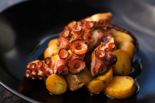 a plate of food with meat and potatoes on it at La Concha Resort, Puerto Rico, Autograph Collection in San Juan
