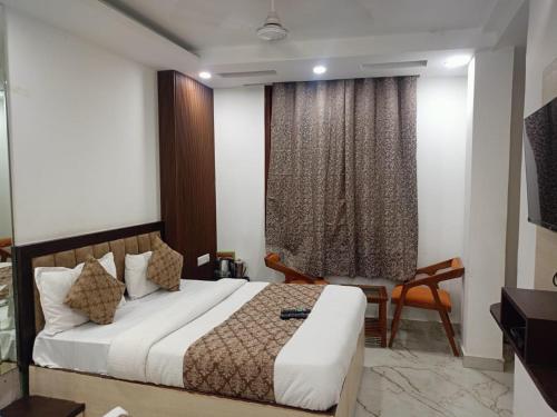 a bedroom with a bed and a chair and a window at Hotel C G Newly Built 2 Mins From Connaught Place and Railway Station & 5 Mins From VFS Shivaji Stadium Metro Station in New Delhi