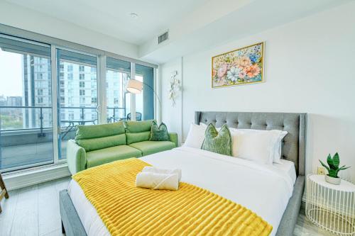 a bedroom with a large bed and a couch at RivetStays - The Jarvis in Toronto