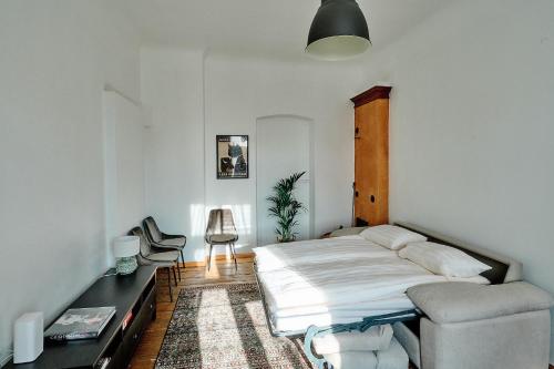 a bedroom with a bed and a chair in it at Your Lutsu Apartment Lux Retro Prime Spot in Viljandi