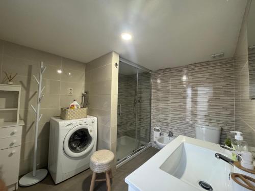 a bathroom with a washing machine and a sink at Casa da Avó Quina - Seixas in Coura
