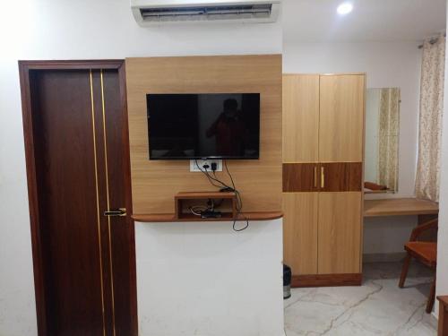a room with a tv on a wall next to a door at Hotel C G Newly Built 2 Mins From Connaught Place and Railway Station & 5 Mins From VFS Shivaji Stadium Metro Station in New Delhi