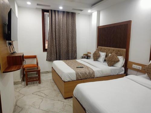 a hotel room with two beds and a television at Hotel C G Newly Built 2 Mins From Connaught Place and Railway Station & 5 Mins From VFS Shivaji Stadium Metro Station in New Delhi